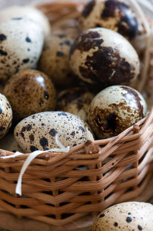 Small quail eggs in a wicker basket. Close up.の写真素材
