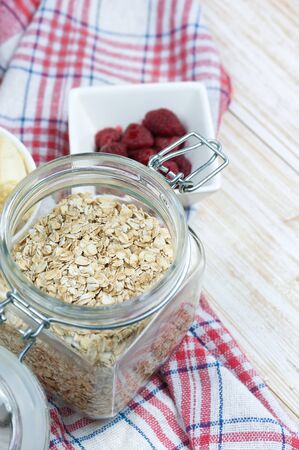 Oat flakes in open glass jar on wooden table.の写真素材