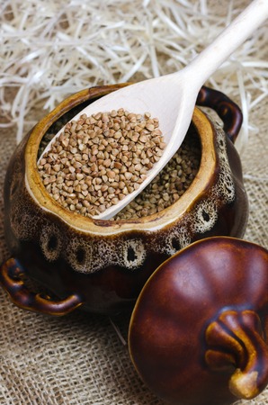Raw buckwheat in a brown clay pot.の写真素材