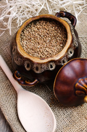 Raw buckwheat in a brown clay pot.の写真素材