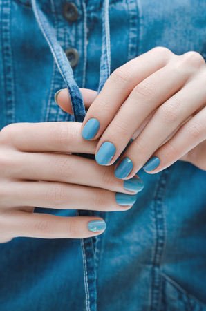 Beautiful female hand with blue nail design.の写真素材
