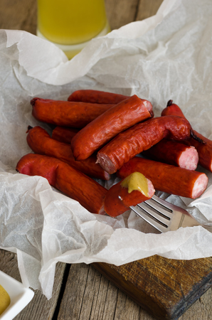 Sausages with mustard sauce on a wooden cutting board.の写真素材
