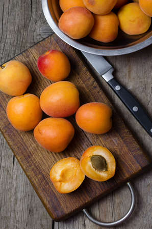 Delicious ripe apricots on wooden cutting board.の写真素材