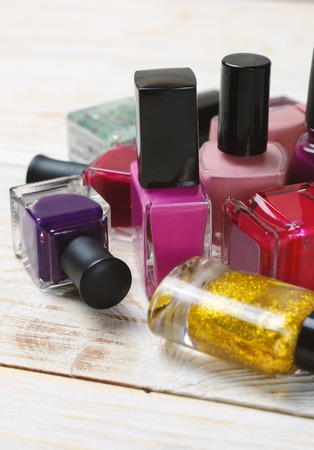 Colorful nail polish bottles on light wooden background.の写真素材