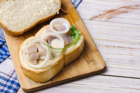 Herring with white onion on a piece of bread.の写真素材