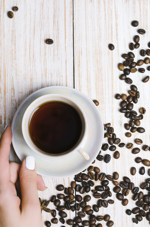 Cup of coffee and coffee beans on white wooden background.の写真素材