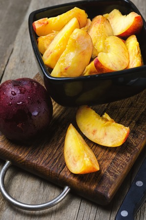 Sliced nectarine on dark wooden cutting board.の写真素材