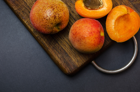 Delicious ripe apricots on wooden cutting board.の写真素材
