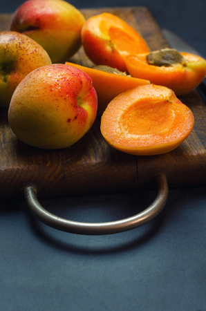 Delicious ripe apricots on wooden cutting board.の写真素材