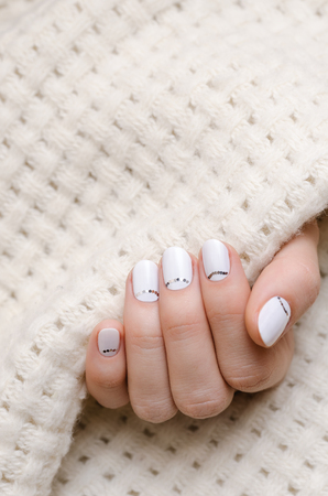 Beautiful female hand with white nail design.の写真素材