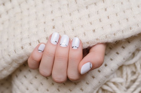 Beautiful female hand with white nail design.の写真素材
