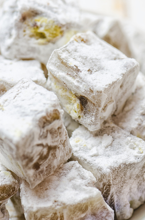 Turkish delight with pistachios on white wooden background.の写真素材