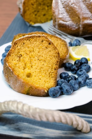 Sliced lemon cake with blueberries on wooden tray.の写真素材
