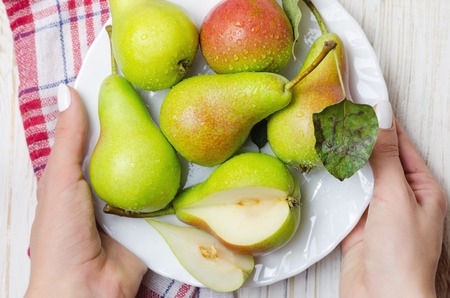 Fresh peaches in white plate on wooden background, closeup.の写真素材