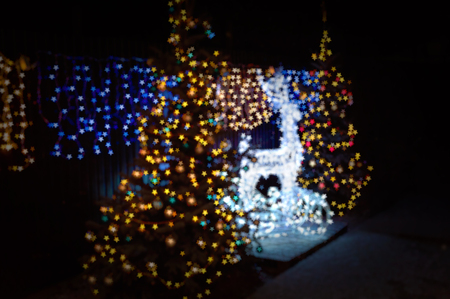 Abstract Christmas background. Blurred bokeh Christmas deer and Christmas trees.の写真素材