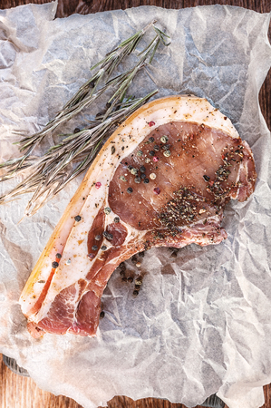 Raw pork chop with rosemary prepared for grill.の写真素材