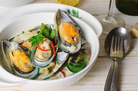 Shellfish mussels in cream sauce with white wine and chili pepper in white plate.の写真素材