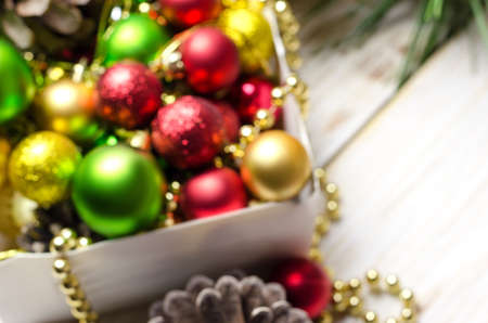 Box with red, golden and green christmas balls. Defocused background.の写真素材