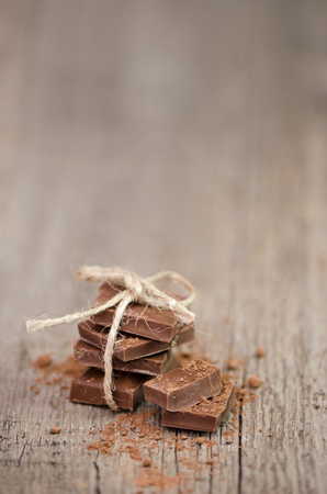 Sweet milk chocolate stack on wooden background.の写真素材