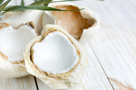 Open young coconut on white wooden background.の写真素材