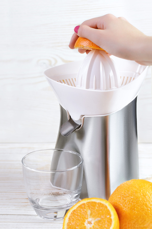 Squeezed orange juice and fresh oranges fruits on white wooden background.の写真素材