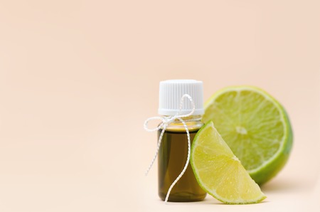 Bottle with lime essential oil and fresh lime.の写真素材
