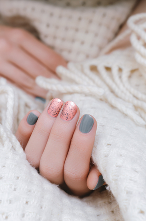 Female hand with pink and gray nail design.の写真素材