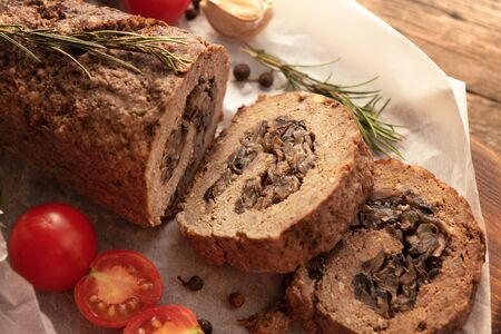 Tasty Meatloaf with mushrooms on wooden tableの写真素材