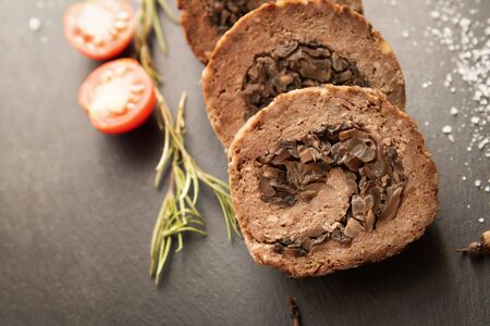 Tasty Meatloaf with mushrooms on black backgroundの写真素材