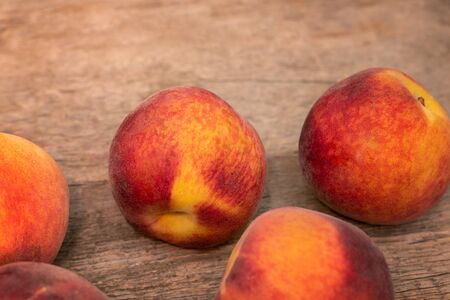 Ripe peaches on wooden background, close upの写真素材