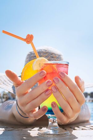 Beautiful girl with glitter nail design holding glass with cocktail.の写真素材