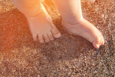Baby feet on the sea pebbles on sunlight.の写真素材