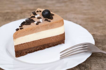 Triple chocolate mousse cake on white plate