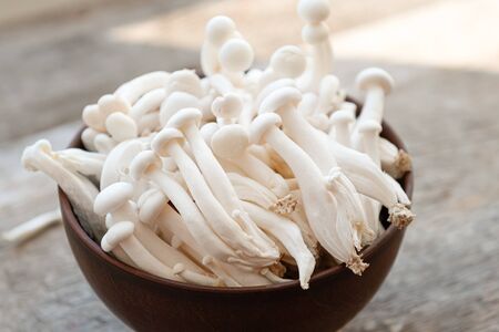 Enoki mushrooms on wooden background, close up
