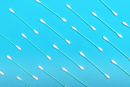 White cotton swabs on blue background.