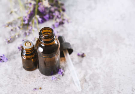 Lavender essential oil in a brown glass bottles with a lavender flowers.の写真素材