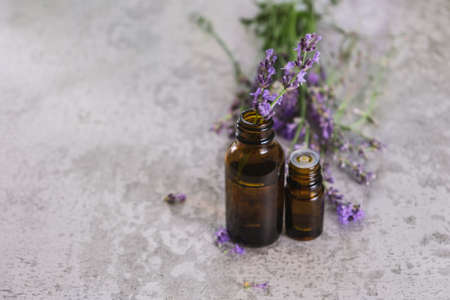 Lavender essential oils. Lavender flowers on stone desk. Medical essential oil bottlesの写真素材