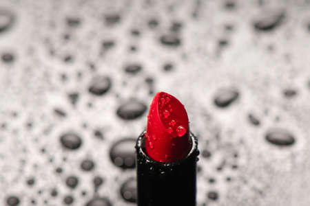 Close up of red saturated lipstick with water drops. decorative cosmetics. Visage and face makeup.の写真素材