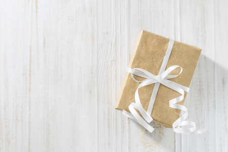 Gift box on the white wooden background. Paper gift box with white ribbon. Valentine's Day gift.の写真素材