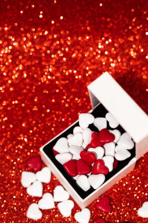 St. Valentine's day gift box full of candies on glitter red backgroundの写真素材