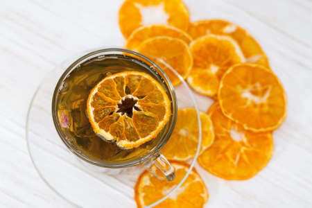black tea. Cup of tea with dried orange. Herbal tea with dried citrus. Black tea cup on white backgroundの写真素材