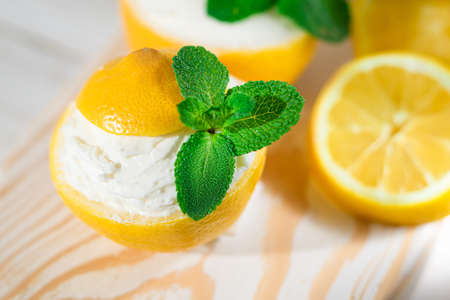 Homemade italian lemon sorbet decorated with mint. Homemade ice cream in lemon decorated with mint. Sorbetto al lemonの写真素材