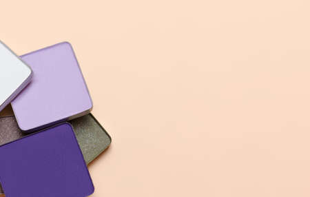 Colorful eye shadow palette with makeup brush. Eye shadow palette on beige background with copy spaceの写真素材