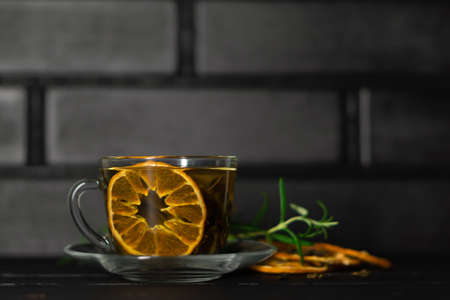 black tea. Cup of tea with dried orange. Herbal tea with dried citrus. Black tea cup on wooden backgroundの写真素材