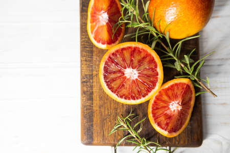 Ripe red oranges on wooden cut board. Sliced ripe juicy Sicilian blood oranges on wooden background. copy space.の写真素材