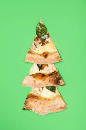 Three mushroom pizza pieces with mozzarella cheese and herbs close up on green background.の写真素材