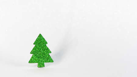 Glitter green paper fir tree toy on a glitter white background. copy space. Christmas greeting cardの写真素材