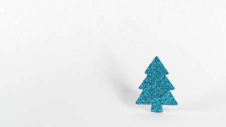 Glitter blue paper fir tree toy on a glitter white background. copy space. Christmas greeting cardの写真素材