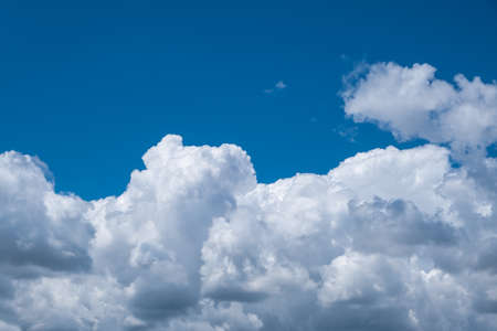 Beautiful white clouds against the blue sky. Blue sky at top and a white cloud at bottom of shot. Tranquility conceptの写真素材