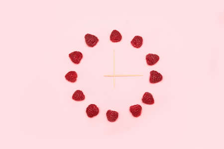 Sun sign made from raspberries. organic food concept. Circle from raspberries isolated on a pink backgroundの写真素材